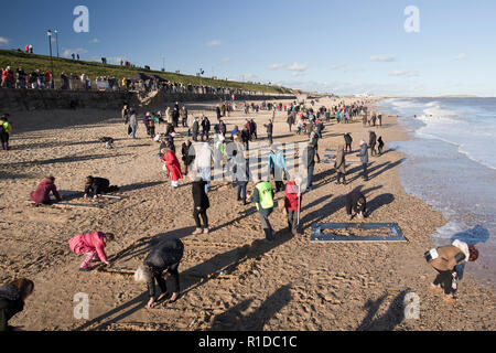 Gorleston-On - Meer, Norfolk. 11. November 2018. Menschenmengen auf Gorleston Strand versammeln sich Danny Boyle's Allgemein "Seiten der Erinnerung" zu beteiligen, markiert das Ende des Ersten Weltkriegs vor 100 Jahren, viele Ihrer eigenen künstlerischen Beiträge im Sand der Erinnerung an die Personen, die unsere Ufer links und kehrte nie zurück. Credit: Adrian Buck/Alamy leben Nachrichten Stockfoto