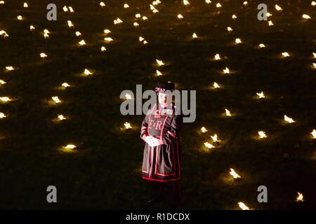 London, Großbritannien. 11. November 2018. Beefeater im Tower von London Wassergraben. Über die Vertiefung der Schatten ist eine Installation, bei der 10000 Flammen für Spenden-infos Sonntag beleuchtet werden. Credit: Dimple Patel/Alamy leben Nachrichten Stockfoto