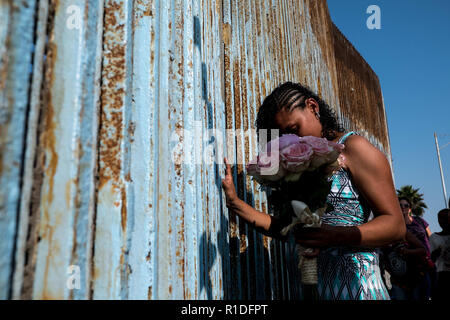 Tijuana, Baja California, Mexiko. November 11, 2018 - KARLA LINDO, 27, eine neue Migranten aus Honduras, berührt der US-mexikanischen Grenze, nachdem sie zu REYNALDO HERNANDEZ, 27 verheiratet, auch ein Migrant aus Honduras, bei Playas de Tijuana in Tijuana, Baja California. Die Paare, die ein Baby erwarten, beantragt Asyl in den Vereinigten Staaten kurz nach der Ankunft in Tijuana am 25. Oktober. Nach dem Paar, Sie haben da eine Bestätigung von der Immigration Beamte erhalten und warten derzeit für die Anforderung vollständig verarbeitet werden. Quelle: Joel Engel Juarez/ZUMA Draht/Alamy Li Stockfoto