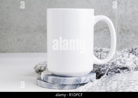 15 oz mug Mockup mit Marmor Untersetzer und eine graue Decke Stockfoto