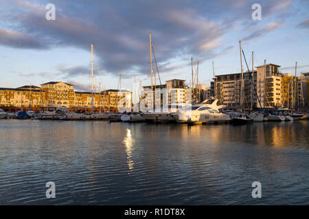 Die Sonne über Sovereign Harbour, fangen die Yachten und Gebäude, auf der ein Winter am Nachmittag Stockfoto