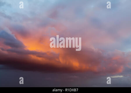 Schöne orange Wolken und Himmel bei Sonnenuntergang mit rosa und violetten Tönen über England UK. Cloudscape und skyscape Hintergrund Stockfoto