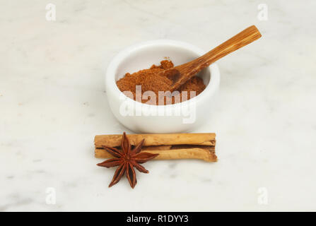 Chinesischen fünf Spice in einem ramekin mit Zimt und Sternanis auf einer marmorarbeitsplatte Stockfoto