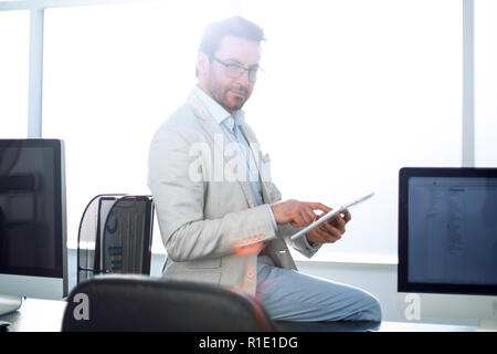 Aufmerksame Geschäftsmann nutzt ein digitales Tablet in einem modernen Büro. Stockfoto