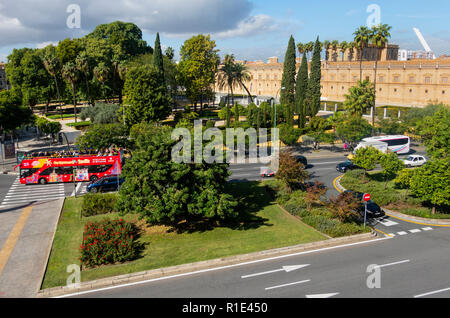 Leuchtend roten, oben offenen site-seeing Bus vorbei an einem Park in Sevilla, Spanien Stockfoto