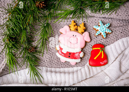 Lebkuchen piggy und Schneeflocke auf dem Hintergrund mit Tannenzweigen, Flach, Ansicht von oben. Urlaub Süßigkeiten. Silvester und Weihnachten Thema. Festliche Stimmung. Weihnachtskarte Stockfoto