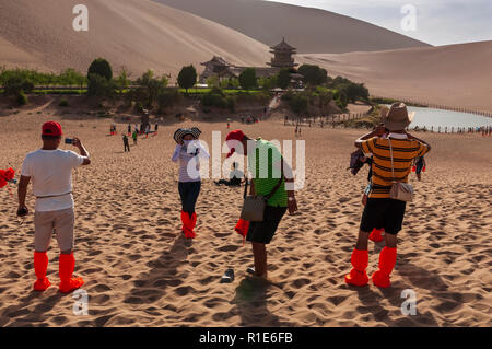 Dunhuang, China - August 8, 2012: Gruppe der chinesischen Touristen im Crescent Moon Lake in der Nähe von Dunhuang in der Provinz Gansu, China. Stockfoto