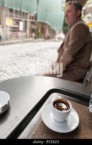 Menschen beobachten mit einer kleinen Tasse starken schwarzen Kaffee in Gjirokaster, Südalbanien. Stockfoto