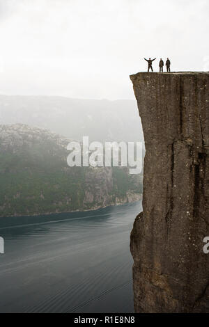 Preikestolen - amazing Rock in Norwegen. Mädchen steht auf einer Klippe oberhalb der Wolken. Preikestolen, der berühmtesten Sehenswürdigkeit in Ryfylke Stockfoto