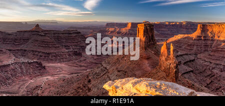 Die ersten Strahlen der warmen Sonnenlicht auf den Mesas weg von Marlboro Punkt über Shafer Canyon in der Nähe von Canyonlands National Park, Utah. Stockfoto