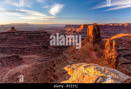 Die ersten Strahlen der warmen Sonnenlicht auf den Mesas weg von Marlboro Punkt über Shafer Canyon in der Nähe von Canyonlands National Park, Utah. Stockfoto