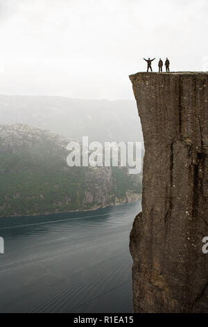 Preikestolen - amazing Rock in Norwegen. Mädchen steht auf einer Klippe oberhalb der Wolken. Preikestolen, der berühmtesten Sehenswürdigkeit in Ryfylke Stockfoto