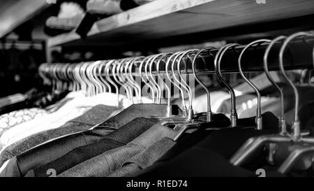 Schwarz-weiß Foto. Kleider auf Kleiderbügeln im Store, Vertrieb Stockfoto