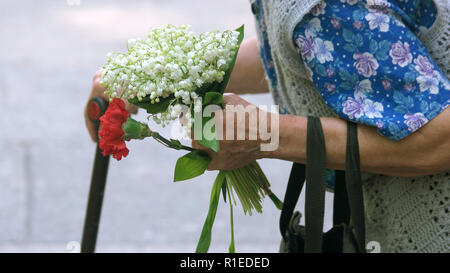Alte Frau mit Blumen, Beschnittenes Bild. Stockfoto
