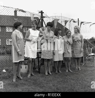 1967, historische, auf einer Wohnanlage, eine Gruppe von Frauen, die in die Kleider des Era außerhalb in einem Feld an einer Schule Sommer Fete, England, UK. Stockfoto