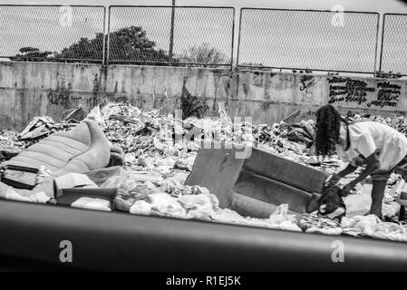 Frau Kommissionierung von Junk-Boden mit genervten Ausdruck in ihrem Gesicht Stockfoto