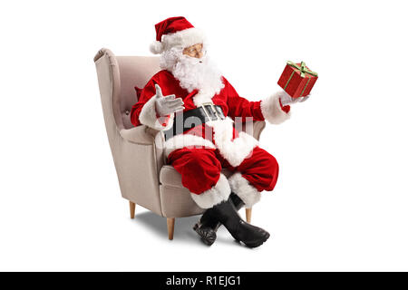 Santa Claus sitzt in einem Sessel und hält eine auf weißem Hintergrund Stockfoto