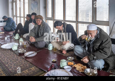 Männer sitzen auf dem Boden ein Mittagessen in einem traditionellen Restaurant, Bamian, Provinz Bamyan, Afghanistan in Stockfoto