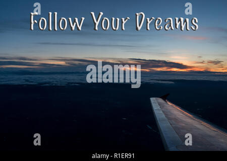 Ihre Träume text auf weiten Himmel und Flügel des Flugzeugs bei Sonnenuntergang folgen. Horizontale Hintergrund Fliegen Flugzeug Stockfoto