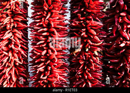 In der Nähe von hellen roten Chili peppers zusammen aufgereiht, genannt ristras, gemeinsame zur Südwestlichen und Mexikanische Küche Stockfoto