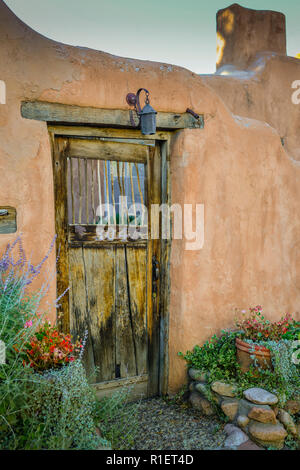 Charmante alte Holztür am Eingang in eine Adobe ummauerten Innenhof in der Innenstadt von Nachbarschaft in Santa Fe, NM