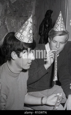 1970 s, historischen, einer Partei, LA, zwei junge Männer mit Party Hüte oder Hütchen auf dem Kopf, einem weht ein Papier Streamer, Los Angeles, USA. Stockfoto