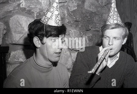 1970 s, historischen, einer Partei, LA, zwei junge Männer mit Party Hüte oder Hütchen auf dem Kopf, einem weht ein Papier Streamer, Los Angeles, USA. Stockfoto