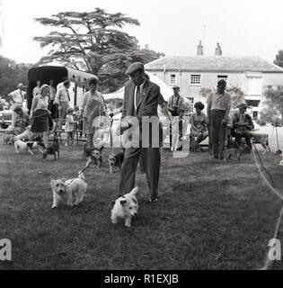 1960, historische, außerhalb auf einer Fete, Hundebesitzer in einem Feld mit ihren Haustieren nehmen an einem Training, England, UK. Stockfoto