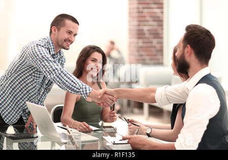 Handshake Geschäftspartner über den Schreibtisch im Büro Stockfoto
