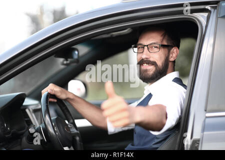 Der Mann im Auto sitzen und mit dem Daumen nach oben. Stockfoto