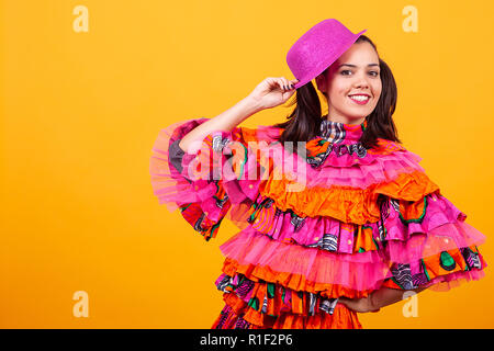 Junge schöne Frau das Tragen einer Maskerade latino Kostüm über Gelb Hintergrund im Studio Stockfoto