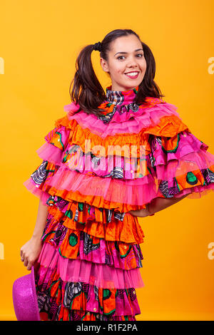 Junge schöne Frau das Tragen einer Maskerade latino Kostüm über Gelb Hintergrund im Studio Stockfoto