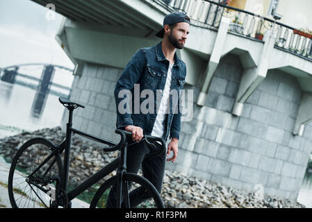 Freizeitaktivitäten im Freien. Junge stilvollen Mann auf der Straße mit dem Fahrrad freuen uns zuversichtlich Stockfoto