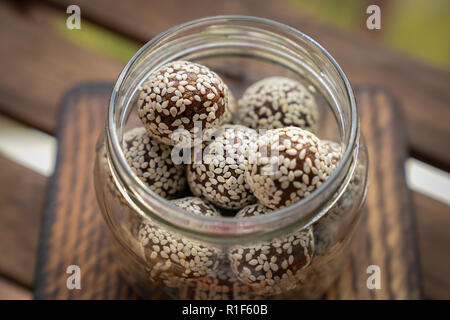 Gesunde hausgemachte Energie Kugeln mit Preiselbeeren, Nüsse, Datteln und Haferflocken auf Pergament, horizontal. Stockfoto