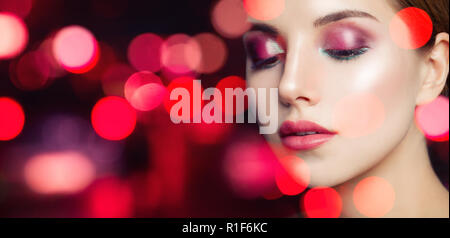 Wunderschöne Frau mit bunten Make-up Party bokeh Glitzer Hintergrund Stockfoto