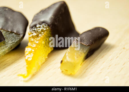 Leckere dunkle Schokolade Pralinen mit Birne, Orange und Ingwer auf einem hölzernen Schneidebrett Stockfoto