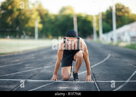 Läufer am Start. Sprinter auf der Startlinie der Schiene im Stadion Stockfoto