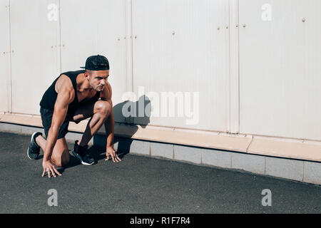 Junger Mann in laufen, stellen auf der Straße der Stadt. sprinter Training Outdoor Stockfoto