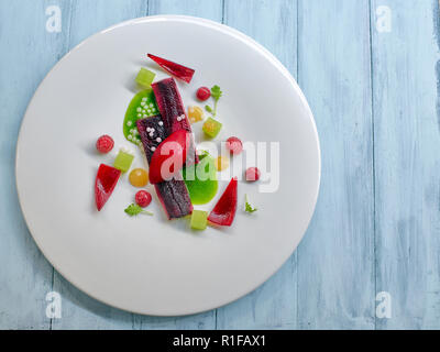 Molekulare lachs Streifen mit Himbeeren icecream und Grün mint Sauce Stockfoto