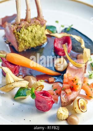 Schweinelende mit Rote-beete-Knödel auf schwarzer Soße mit saisonalen cooced Gemüse Stockfoto