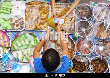 Overhead Schuß über Vielfalt an leckeren und bunten Malaysischen hausgemachte Kuchen aus der Region oder "KUEH' bedeckt mit Kunststoff Staub auf der Straße mar verkauft zu vermeiden. Stockfoto