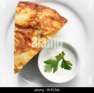 Spanisches Omelette mit saurer Sahne in einem Restaurant. Stockfoto