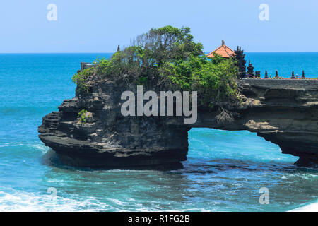 Landschaft der Insel Bali Ufer mit dunklen blauen Indischen Ozean, Wellen und schwarzen Klippe mit Tempel Stockfoto