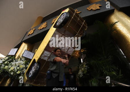 Hong Kong. 12 Nov, 2018. Mann, der einen Papier-gestaltete 'Auto', einem chinesischen traditionellen Angebote für den späten Hong Kong Wuxia Romancier, Jin Yong (Alter 94) aus der Leichenhalle während des Memorial Service. Nov-12, 2018 Hong Kong. ZUMA/Liau Chung-ren Credit: Liau Chung-ren/ZUMA Draht/Alamy leben Nachrichten Stockfoto