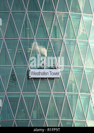 12. November 2018, Hessen, Frankfurt/Main: Arbeiter Reinigen der Glasfassade der Westhafen Tower in Frankfurt mit Hochdruckreinigern. Da das Bürogebäude ähnelt einem traditionellen Apfelwein Glas, Frankfurter nennen es auch "Die gerippten'. Foto: Arne Dedert/dpa Stockfoto