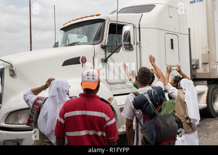 Guanajuato, Guanajuato, Mexiko. 12. Nov 2018. Honduranische Flüchtlinge mit den Zentralamerikanischen Migrantinnen Karawane versuchen Flagge auf vorbeifahrende Lastwagen auf ihrer Reise in Richtung Nordwesten nach der US-Grenze November 12, 2018 in Guanajuato, Guanajuato, Mexiko, um fortzufahren. Die Karawane wurde auf der Straße für ein Monat ist auf halbem Weg entlang ihrer Reise nach Tijuana. Credit: Planetpix/Alamy leben Nachrichten Stockfoto