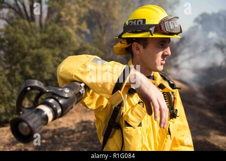 Simi Valley, Kalifornien, USA. 12 Nov, 2018. Eine junge Los Angeles Feuerwehrmann sieht sich um auf heiße Stellen am Fuß Hill Park. Quelle: Chris Rusanowsky/ZUMA Draht/Alamy leben Nachrichten Stockfoto