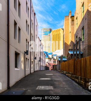 Alte Stadthäuser auf Cambridge Street, in den Felsen, mit Blick auf die Hochhäuser der modernen Sydney Stockfoto