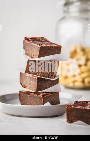 Raw Vegan Schokoladenkuchen Schichten auf weißem Hintergrund. Auf Basis pflanzlicher Ernährung Dessert. Stockfoto