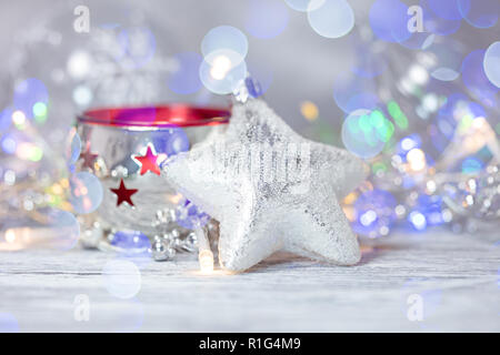 Christbaumschmuck gegen verwackelte glühenden Lichter Hintergrund. winter Urlaub Dekorationen Stockfoto